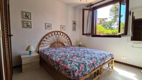 a bedroom with a bed and a window at Appartamento- La Casa del Mirto- Porto Rotondo in Porto Rotondo