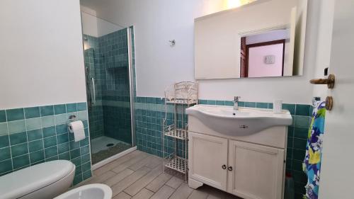 a bathroom with a sink and a toilet and a mirror at Appartamento- La Casa del Mirto- Porto Rotondo in Porto Rotondo