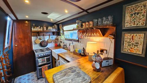 a kitchen with a wooden table in a trailer at Cosy Narrowboat Benedict, Clarence Dock Leeds in Hunslet