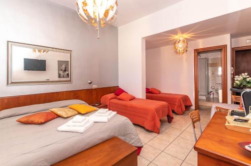 a bedroom with two beds and a couch and a desk at Spiagge Iblee in Marina di Ragusa