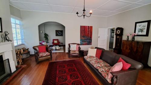 a living room with a couch and chairs at Plum Cottage in Balgowan