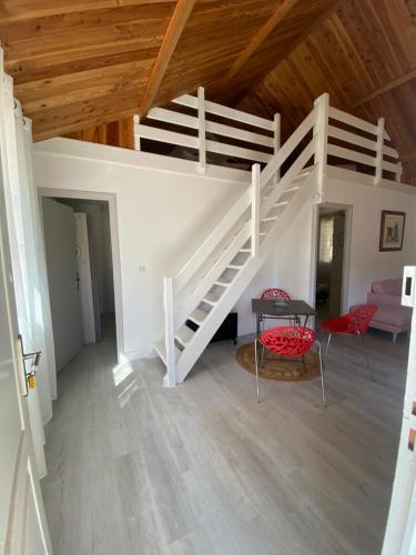 a white staircase in a room with a table and chairs at Les Hauts Complex in Coulaures