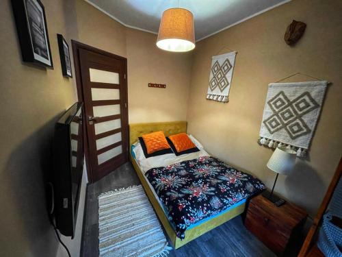 ein kleines Schlafzimmer mit einem Bett und einem TV in der Unterkunft Apartament Brown Sugar Karwia in Karwia