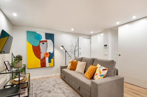 a living room with a couch and a painting at Niko Studio City Center By Sé Apartamentos in Braga