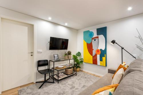 a living room with a couch and a tv at Niko Studio City Center By Sé Apartamentos in Braga