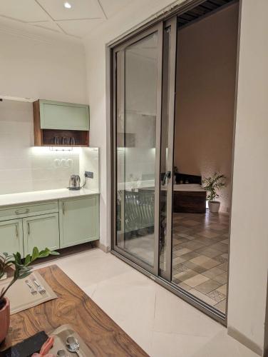 a kitchen with a sliding glass door leading to a patio at Cape House in Amritsar