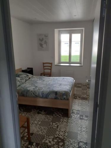 a bedroom with a bed and a window at Frasne logement entier. Gîte les Brimbelles in Frasne