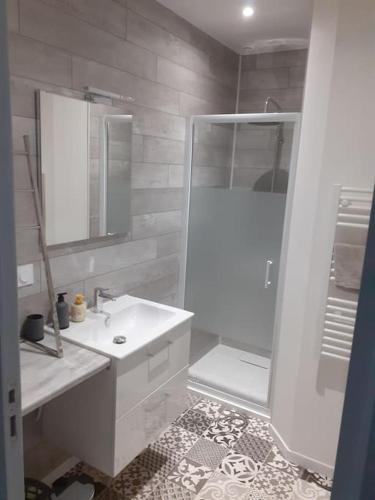 uma casa de banho branca com um chuveiro e um lavatório. em Frasne logement entier. Gîte les Brimbelles em Frasne