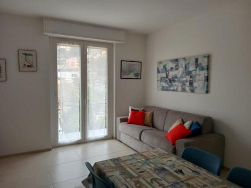 un soggiorno con divano e tavolo di Appartamento Pleiadi a Finale Ligure