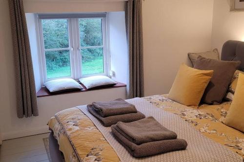 Whitwell的住宿－Fossil Cottage (Berryl Farm Cottages)，一间卧室配有一张床,上面有两条毛巾