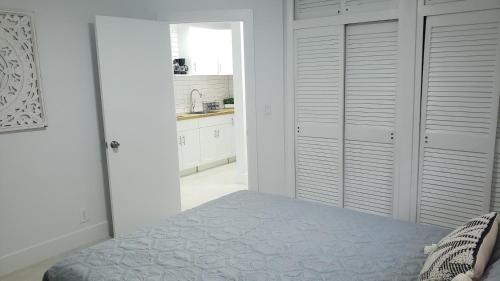 a white bedroom with a bed and a kitchen at Funston in Hollywood