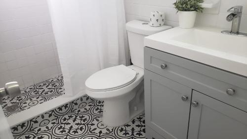 a white bathroom with a toilet and a sink at Funston in Hollywood