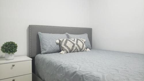 a bed with a gray headboard and a pillow on it at Funston in Hollywood
