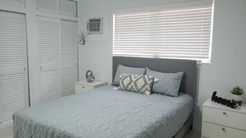 a bed in a bedroom with white walls and a window at Funston in Hollywood