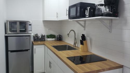 a kitchen with a sink and a microwave and a refrigerator at Funston in Hollywood