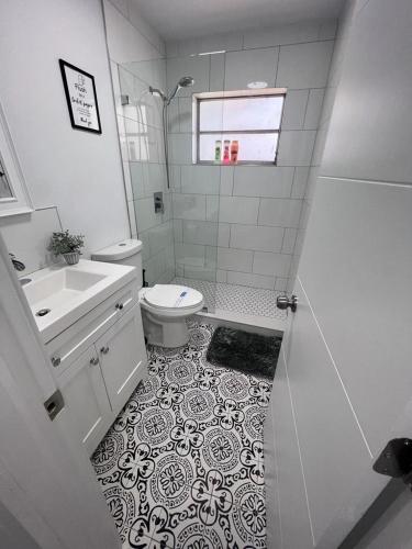 a white bathroom with a toilet and a sink at Funston in Hollywood
