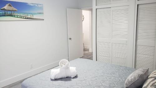 a white bedroom with a bed with a towel on it at Funston in Hollywood
