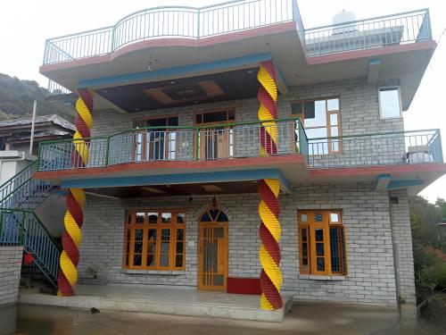 a building with colorful decorations on the side of it at Travelodge Homestay in Bīr