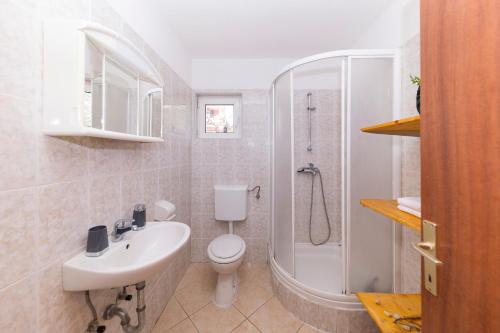 a bathroom with a sink and a toilet and a shower at Apartments Seaside in Bibinje