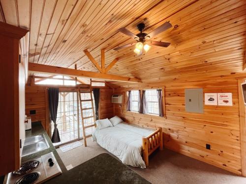 1 dormitorio con 1 cama en una cabaña de madera en Deluxe Cabin6 Within Campground, en Mifflinburg