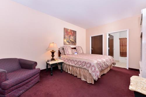 a bedroom with a bed and a couch at Americas Best Value Inn Somerville Texas in Somerville