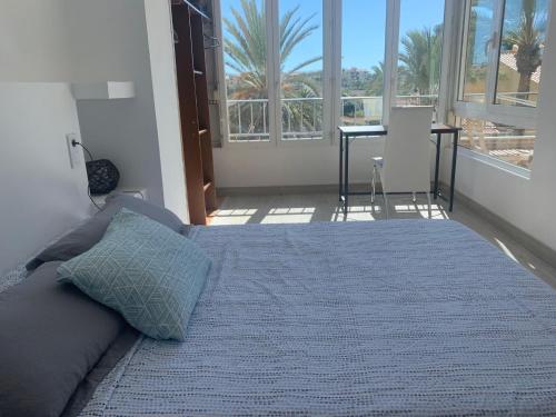 1 dormitorio con 1 cama con manta azul y ventanas en Nice apartment near the sea, en Torrevieja