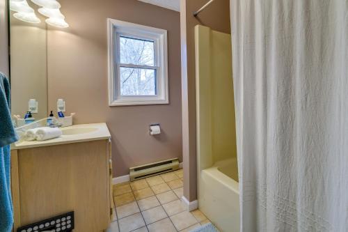 Un baño con ducha, lavabo y bañera. en Lovely Poconos Cabin with Resort Amenities!, en Gouldsboro