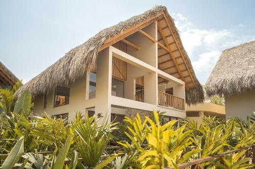 サン・アンテロにあるHotel Aimarawaの茅葺き屋根のリゾートビル