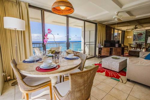 a dining room with a table and chairs with a view of the ocean at Hawaiian Princess Makaha in Waianae