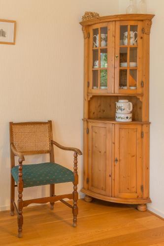 ザイドラーレンにあるB&B Schipborgの木造のキャビネットとオーチ横の椅子
