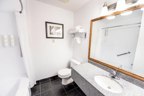 a bathroom with a sink and a toilet and a mirror at Bayshore Inn & Spa in Waterton Park