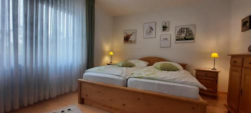 una camera da letto con un letto con due lampade e una finestra di Outdoor & Relax Blackforest a Neukirch