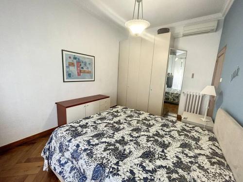 ein Schlafzimmer mit einem Bett mit einer schwarzen und weißen Decke in der Unterkunft Appartement niçois - bord de mer in Nizza