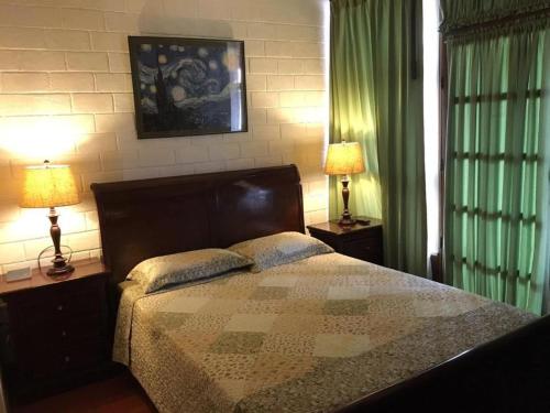 a bedroom with a bed and two lamps on tables at Sura in San José