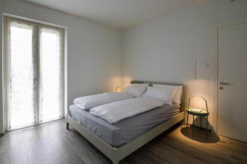 a bedroom with a bed with white sheets and a window at Ca’ del Riccio verde in Bra