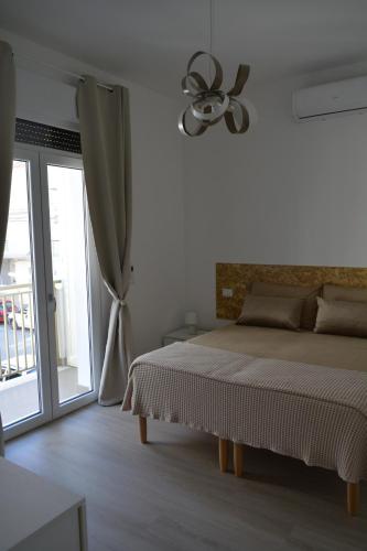 a white bedroom with a bed and a window at Dimora Mucci in Termoli