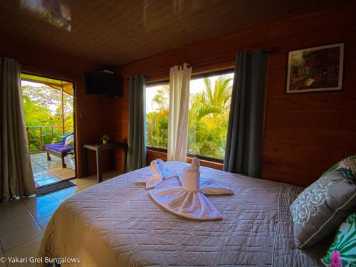 1 dormitorio con 1 cama con tabla de surf en Bungalows Yakari Grei en San Ramón