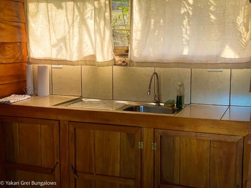 een kleine keuken met een wastafel en een raam bij Bungalows Yakari Grei in San Ramón
