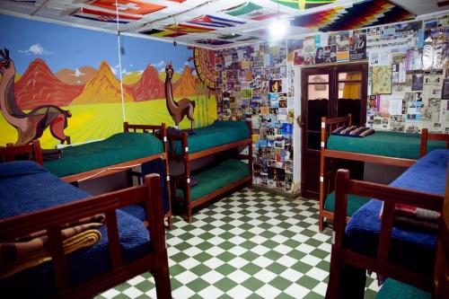 um quarto com 3 beliches e um mural em Apapacho Hostel em Tilcara