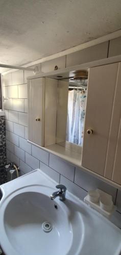 a bathroom with a white sink and a mirror at The Cozy Yard in Nea Potidaea