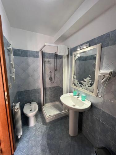 uma casa de banho com um lavatório, um chuveiro e um WC. em Umberto Street em Catânia