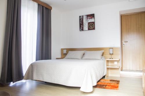 的住宿－Casa Lagar de Pedra T2，卧室配有白色的床和窗户。