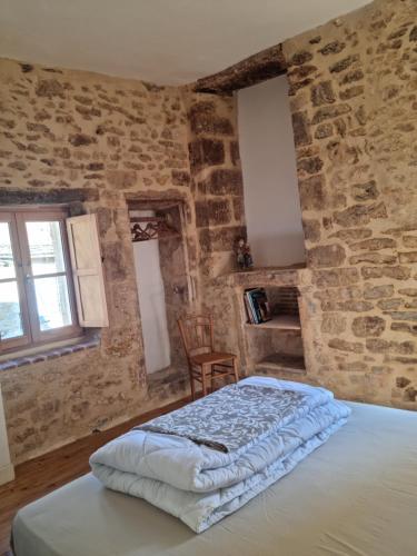 - une chambre avec un lit dans un mur en pierre dans l'établissement Maisonnette au Cœur de la cité Médiévale., à Sarlat-la-Canéda
