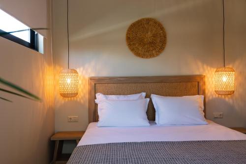 a bedroom with a bed with two pillows and two lights at Isla Luxury Apartment - Private Pool - 100m from the beach in Rethymno Town
