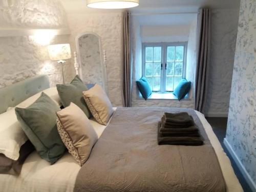 - une chambre avec un grand lit, des oreillers et une fenêtre dans l'établissement The Bake House (Berryl Farm Cottages), à Whitwell