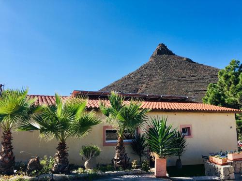 une maison avec des palmiers en face d'une montagne dans l'établissement Tenerife Nature Retreat, à Ifonche
