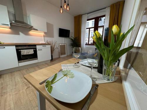 a kitchen with a table with a white plate and wine glasses at Herrliches wohnen mit Teichblick in Altenburg