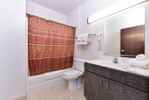 a bathroom with a toilet and a sink and a mirror at Americas Best Value Inn Somerville Texas in Somerville