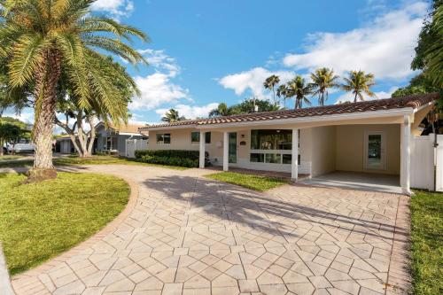 una casa con palmeras frente a una entrada en Kasa Palm Grove Fort Lauderdale, en Fort Lauderdale