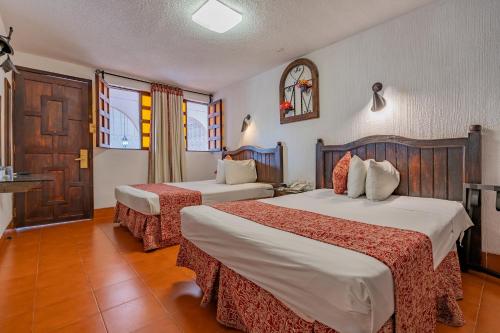 a hotel room with two beds and a window at Hotel Maya Yucatan in Mérida